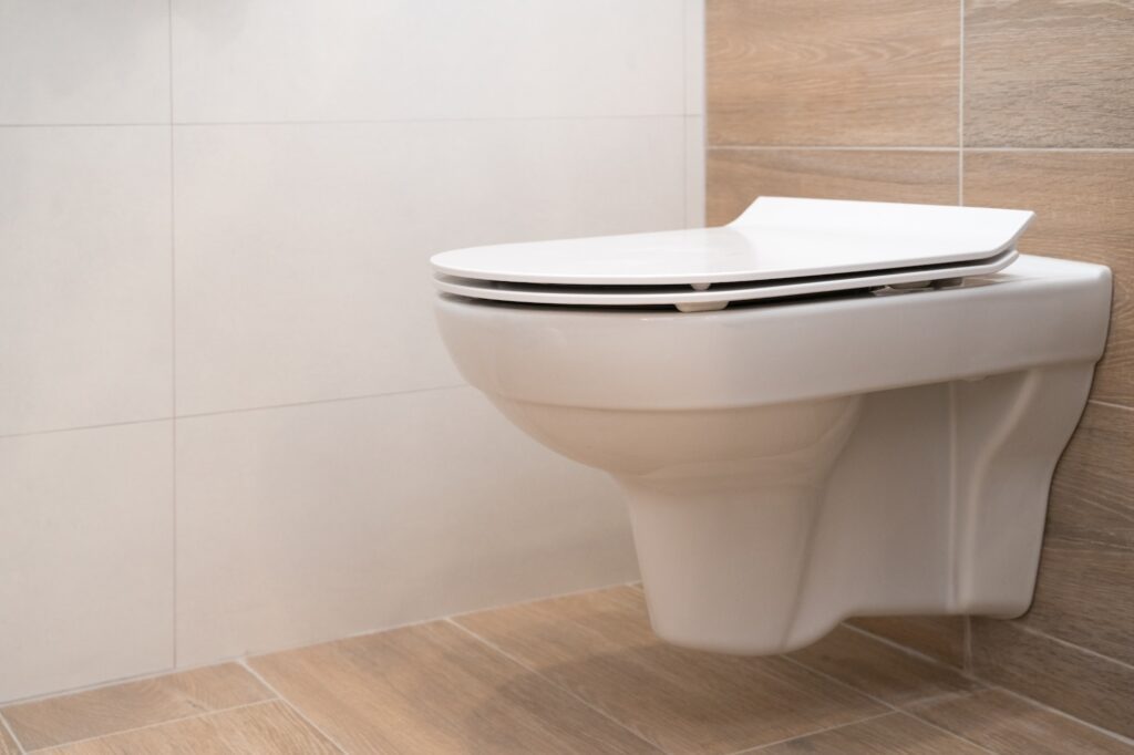 white ceramic compact toilet bowl with built-in cistern in the wall